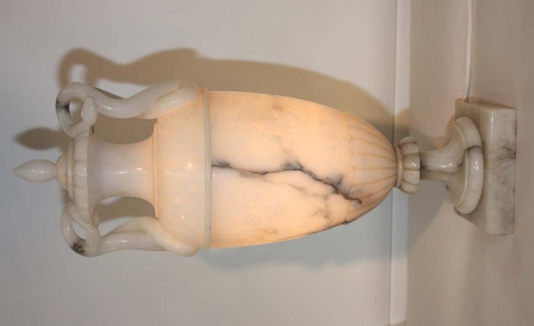 Covered alabaster urn, the lid with snake form handles, the footed body with interior light.