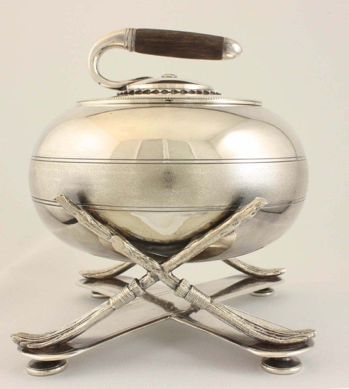 Victorian silver plate biscuit box with rosewood handle, formed as a curling stone raised on crossed brooms over X-base on flattened bun feet. Marked Fenton Brothers of Sheffield; British registration lozenge of 1875.