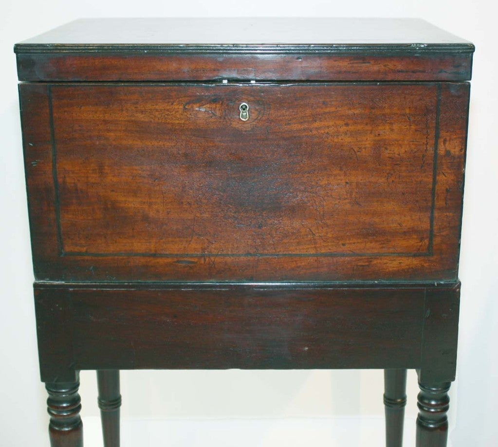 Georgian mahogany tea caddy with ebony edging and stringing,   and brass bail handles, raised on mahogany stand; the interior fitted with two tea  canisters and one teapot warmer-steamer, all with japanned lids.
