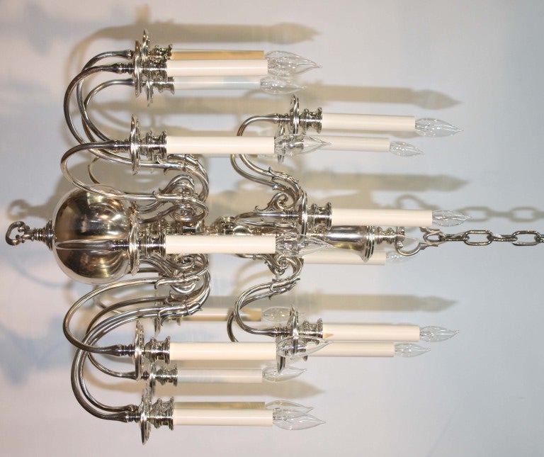 Flemish style silvered bronze chandelier issuing two tiers of double s form candle arms; the bottom finial acting as a three position light switch, lighting first the lower twelve lights, then adding the six arms on the upper tier, then switching
