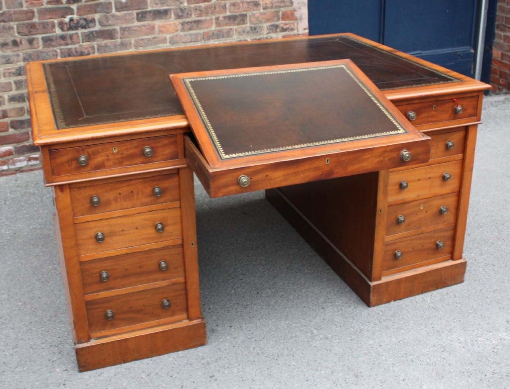 This desk is ideal for working at large projects even without a partner .It has a good sized tooled leather inset top and each central drawer has a sloped reading slide. Each side has a bank of drawers and a large cupboard.  Unusually it retains its