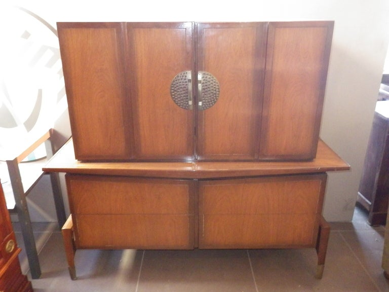 Very elegant tall dresser by Bert England. Top compartment is attached to bottom. Top features double doors with interior drawers when opened. Bottom is composed of four drawers.
Brass handles and leg ends.