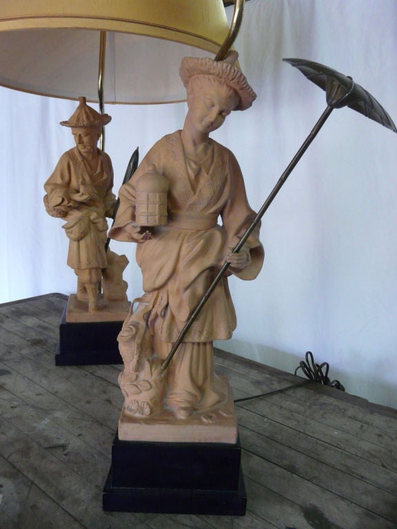 Original bronze parasols and beautifully detailed modeling. The female figure carries a lantern in one hand and long, open parasol in the other, while the male figure carries a cockatoo in one hand and a man's shorter parasol in the other.