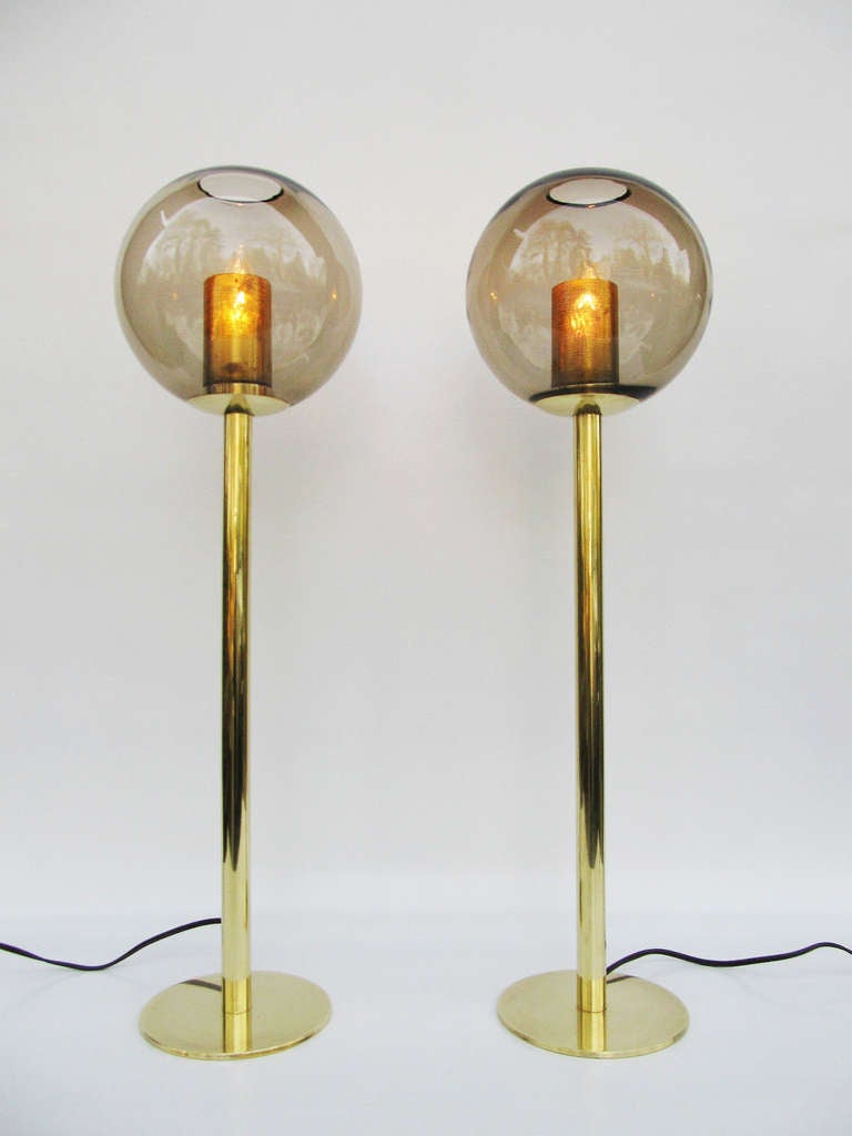 Rare pair of elegant, soft light, table lamps by Swedish designer Hans Agne Jakobsson for Markaryd Sweden circa 1950's. Lamps feature beautiful, blown glass, smoked amber globes with perforated brass diffusers, supported by minimalist brass pedestal