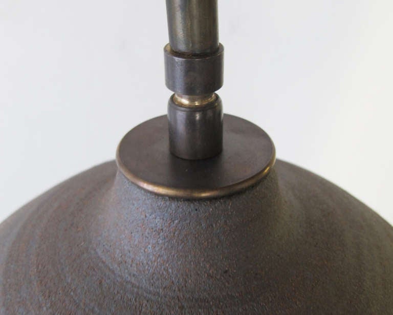 Brass-armed/earthenware form wall lamp.