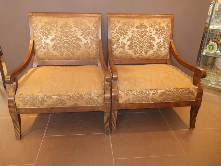 Beautiful pair of wooden-framed armchairs with floral upholstery. These armchairs are very large in size and make an equal impression. The elegantly designed frame compliments the grandness of the whole chair.

