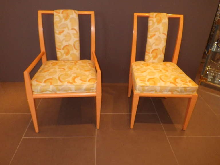 Beautiful set of 8 dining chairs by Tommi Parzinger. Two armchairs and six regular chairs. The frame is a light peach color. Upholstery has a patterned design with matching colors. Beautiful set of chairs.