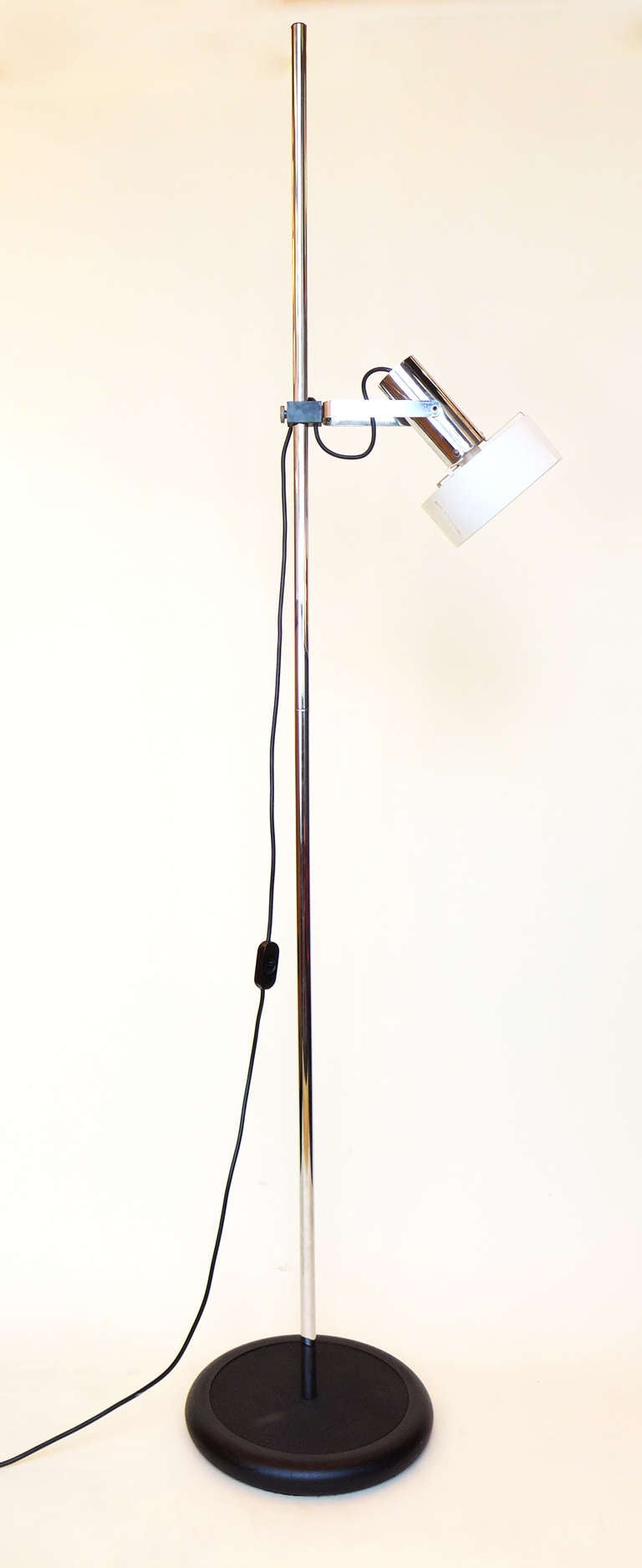 1960s Stilnovo adjustable floor lamp. The base and pole are fixed, while the actual lamp swivels to point up, down, or straight forward. It also swings all the way around and can be elevated or lowered on the pole itself. Chrome finish to the pole,