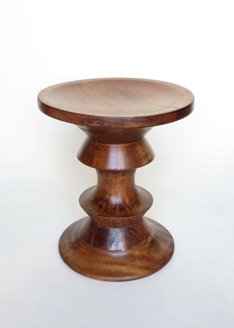 A spun mid-century wood stool by Charles & Ray Eames for Herman Miller.