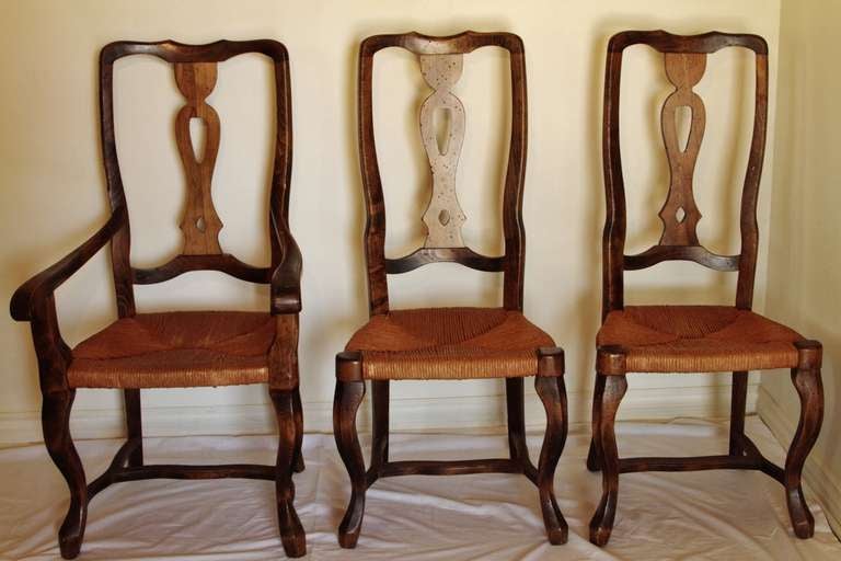 These beautiful dining chairs are made of solid walnut and have a semi-rustic finish. The seats are made of woven straw and are in near-perfect condition. Two armchairs and four arm less.

**Please contact us in advance if you would like to view