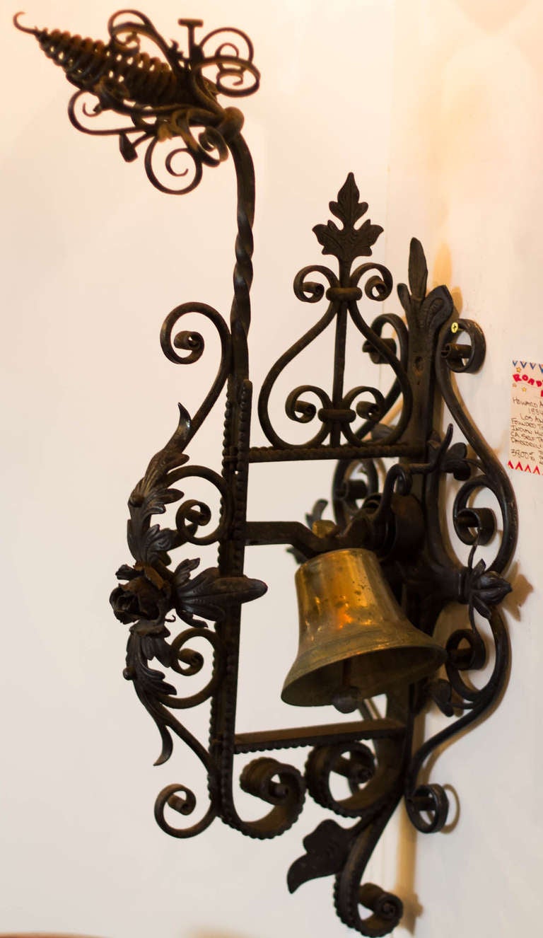 From an old Santa Barbara estate, an exceptional circa early 1900's Spanish Revival wrought iron garden gate bell, hand crafted with superb attention to detail.  Stylized floral and leaf elements adorn the substantial ornate frame; a brass bell is