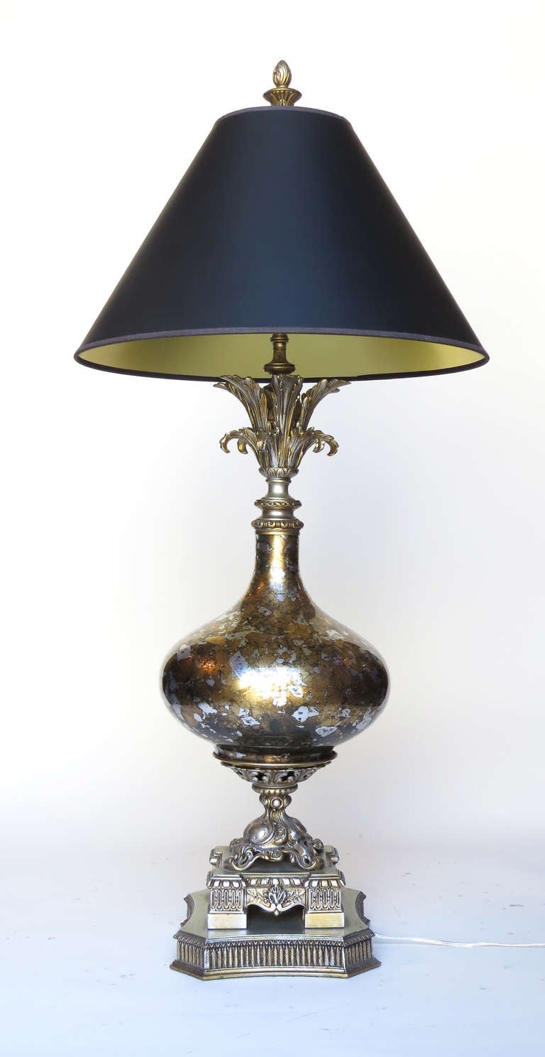 Hollywood regency lamp with gilded glass body and carved base. Beautiful adornments.