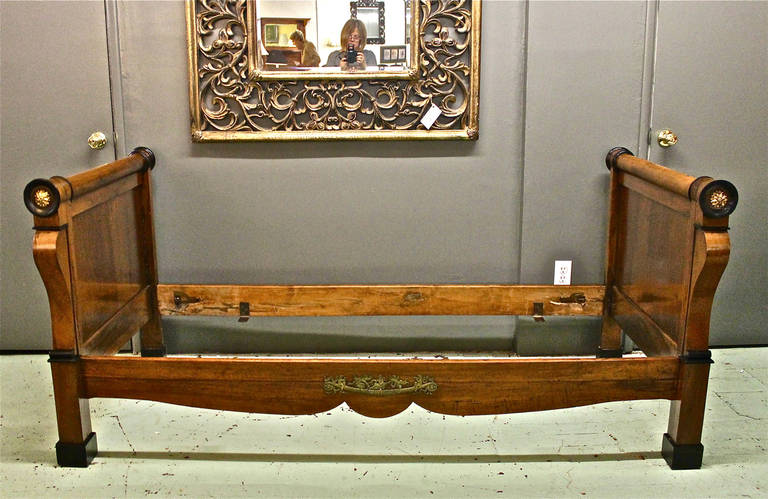 This is a charming antique Biedermeier (perhaps French Restauration) Daybed that dates to the early 19th century. The beautifully figured walnut is highlighted by ormolu mounts to the front side rail and posts. The daybed is in excellent condition