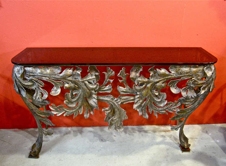 Gorgeous cast iron console dating to the second half of the 20th c. The console is beautifully detailed with applied cast iron acanthus leaves that have been gilded and patinated. The acanthus leaf motif, bombe front legs and faux bois back legs are