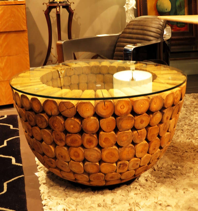 Beautiful wood side table with glass top. The table base is composed of dozens of individual wood stubs that have been cut at angles to create the rounded shape of the piece.
