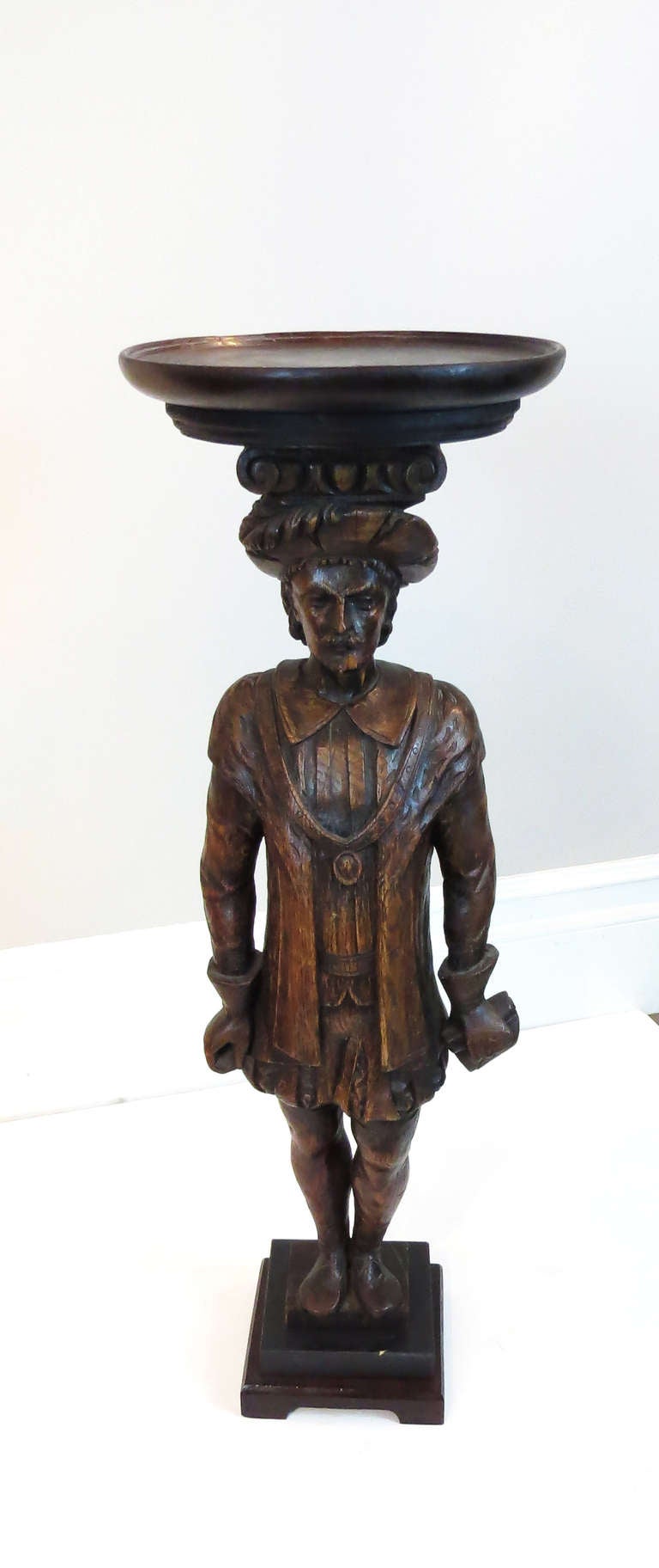 Very interesting hand-carved statue with pedestal top. The entire piece is made of carved wood with a dark finish.