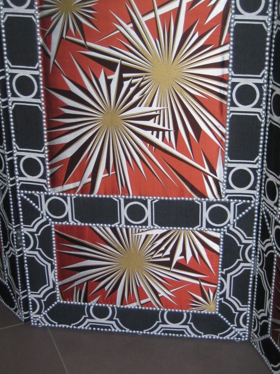 Elegant four panel screen featuring Tony Duquette fabric with starburst print on one side and circle motif on reverse.  Matte silvered upholstery nails create accent to fabric design.