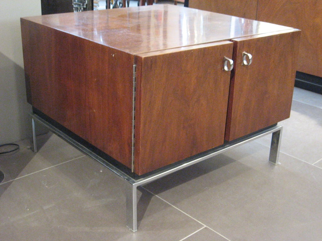 Small and low console with two swing out doors with small chrome finger pulls and sleek matching mid century base. Body and doors of console constructed of American walnut