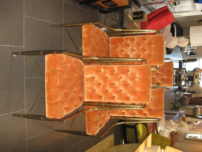 Exquisite dining set of orange upholstered chairs with sleek brass frame
