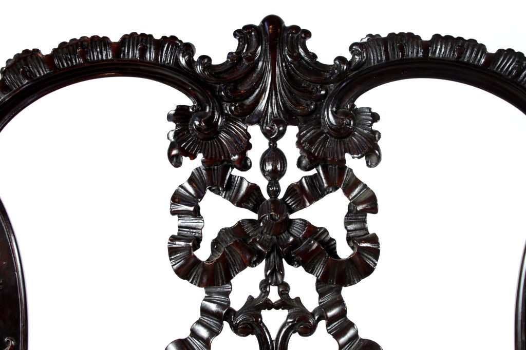 A finely carved pair of 19th century high style Irish hall chairs done in the Chippendale style. Large proportions.