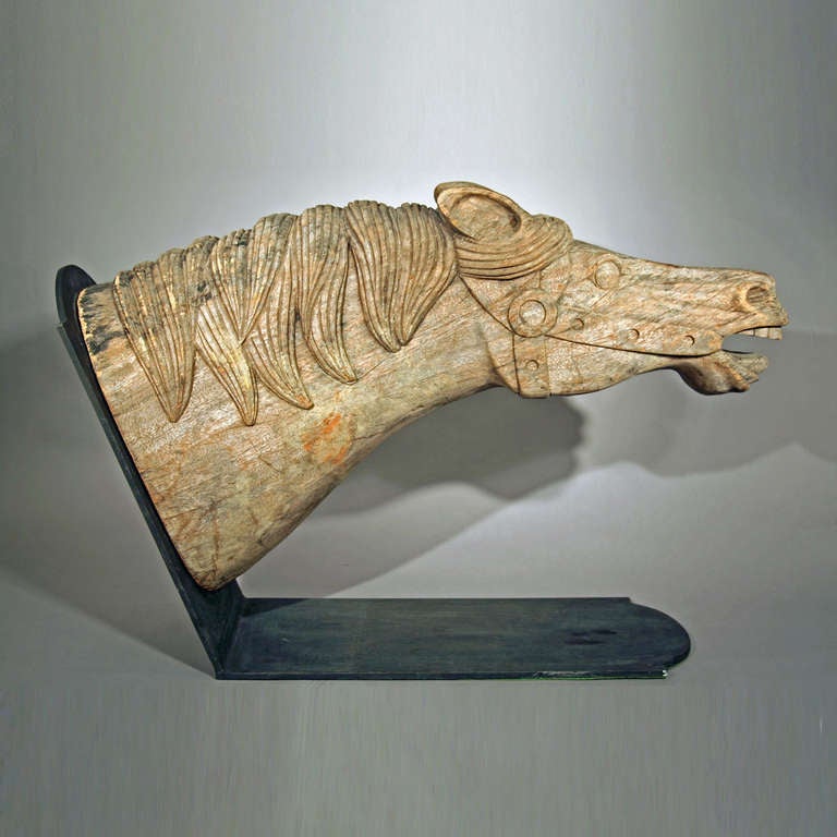 American, second half of the 19th c.
Carved hard wood, metal stand
Fine condition with weathered surface.
The Horse Head appears to be from an early carousel figure and shows great attention to the  detailed carving.