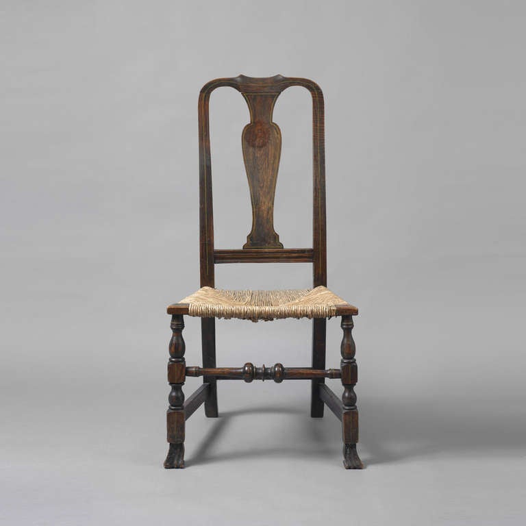 New England, ca. 1740-1750.    
Early Queen Anne Grain Painted Spanish Foot Side Chair.  The chair has a yoked crest above a vasiform splat and trapezoid seat supported on carved Spanish feet.  The chair has a wonderful mid 19th c. grain painted