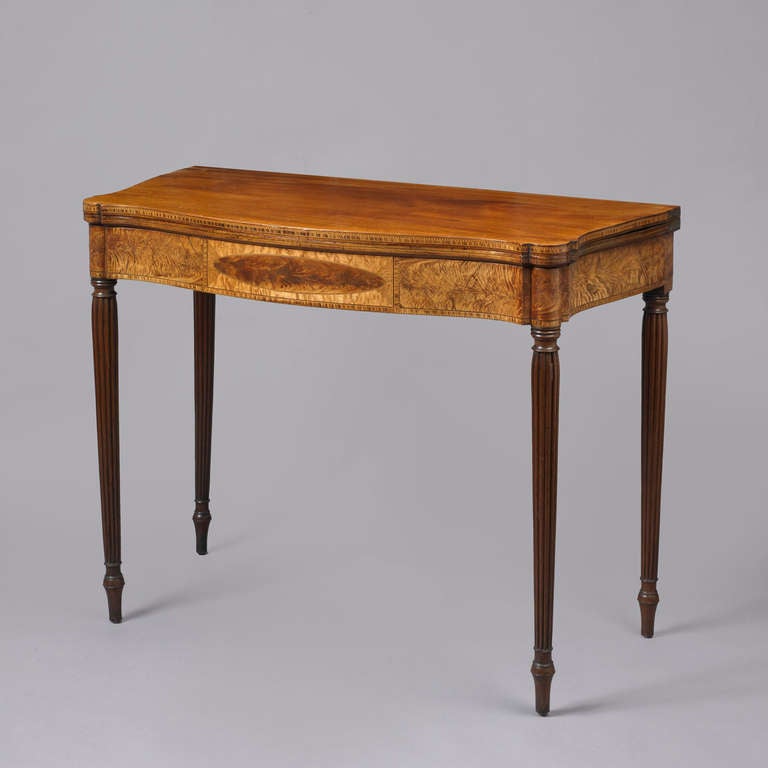 Massachusetts, probably North Shore, ca. 1800-1815.
Mahogany, mahogany veneer, bird's-eye maple, various inlaid woods; white pine and maple secondary woods.  The table has a bow front with elliptical sides above conforming skirt rails adorned with