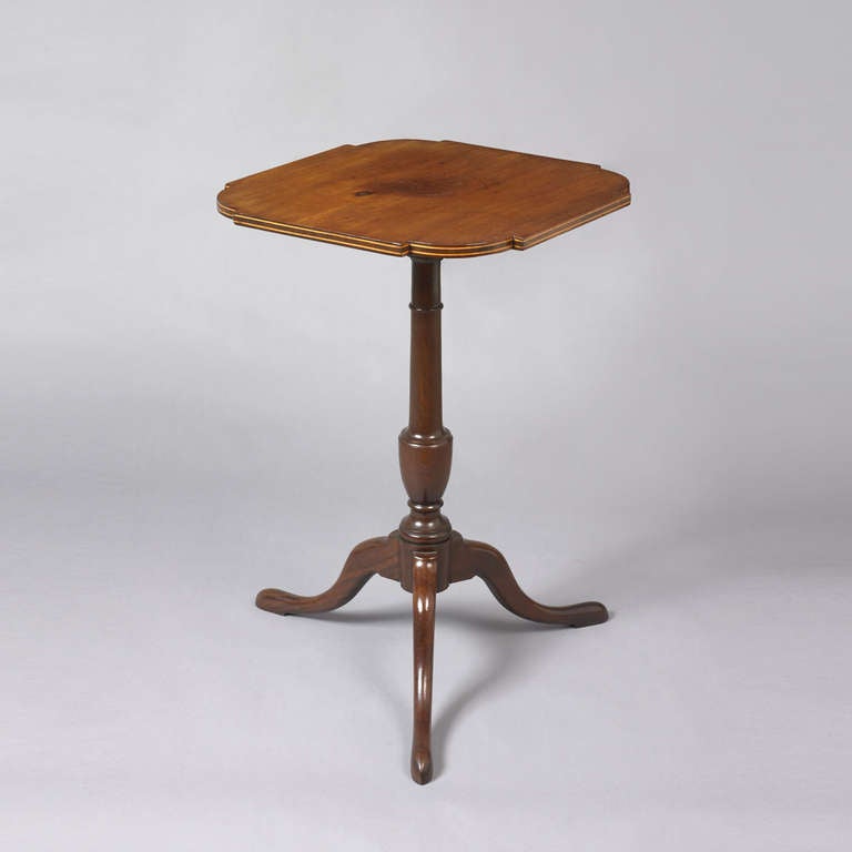 Probably Massachusetts, ca. 1800-1810.
Mahogany
Having a square top with inset ovolo corners finished with an inlaid banded top above an urn form turned shaft supported by snake feet.