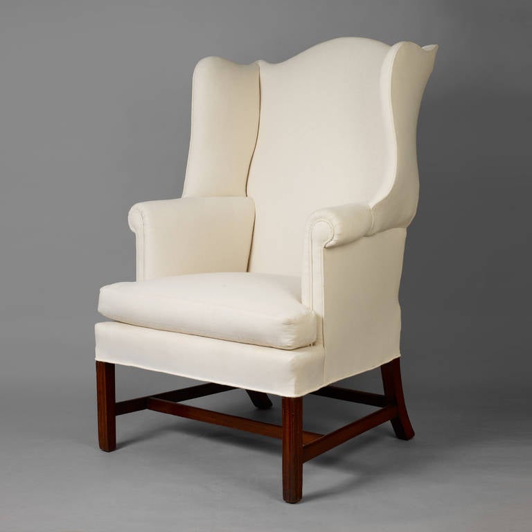 Probably Massachusetts, ca. 1780.
Mahogany, pine secondary wood
Condition: Frame is all original with some replaced blocking and structural reinforcement. 
This wing chair has many fine attributes, such as, the form, quality of the cabinetry and