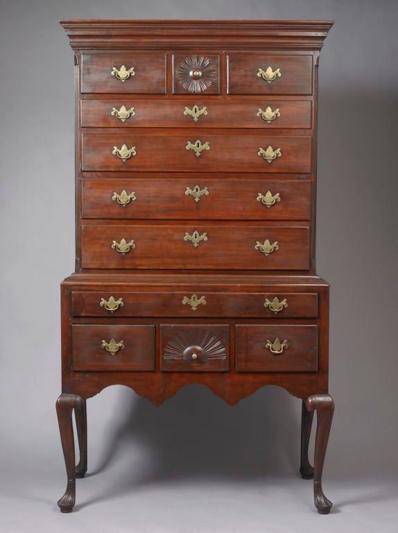 Probably Glastonbury, Connecticut

circa 1750-1780

The upper section is comprised of a compound molded overhanging top above three small drawers. The central square drawer features a carved, radiating and undulating fan and central roundel over
