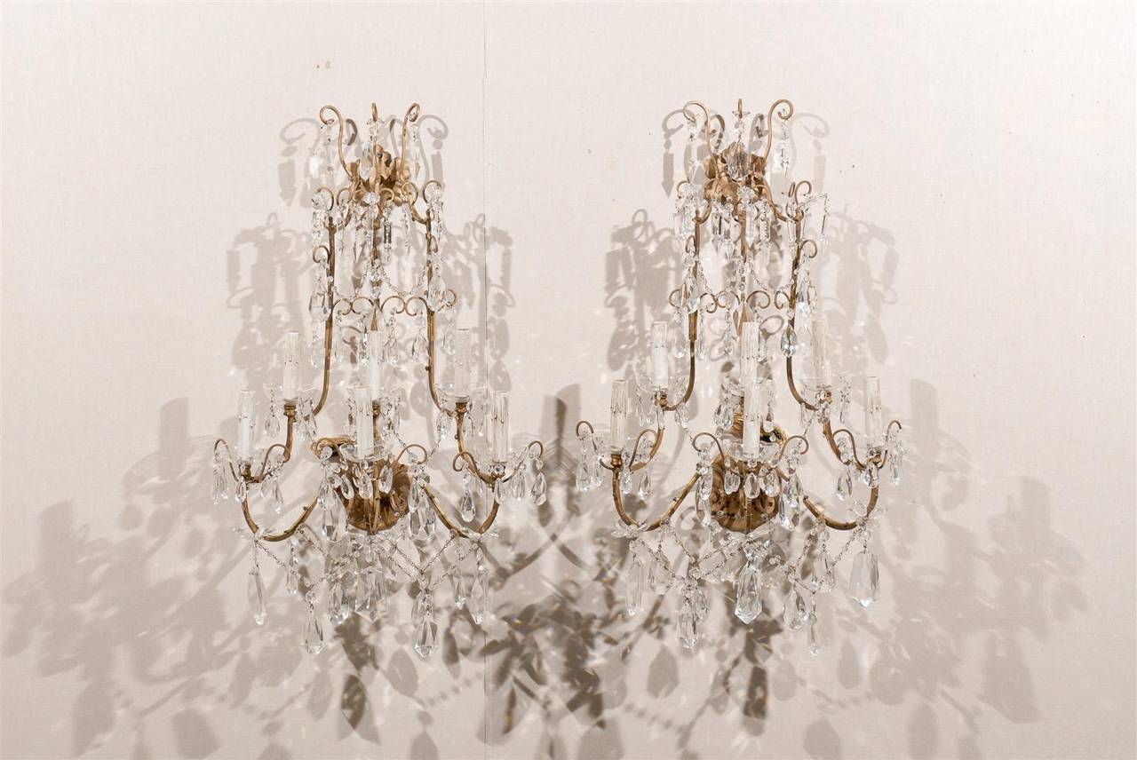 This gorgeous pair of six-light crystal Italian sconces is made of scrolled arms in the upper section, to which delightful spear crystals and faceted crystals are attached.

The arms supporting the glass bobeches with the painted candle sleeves are