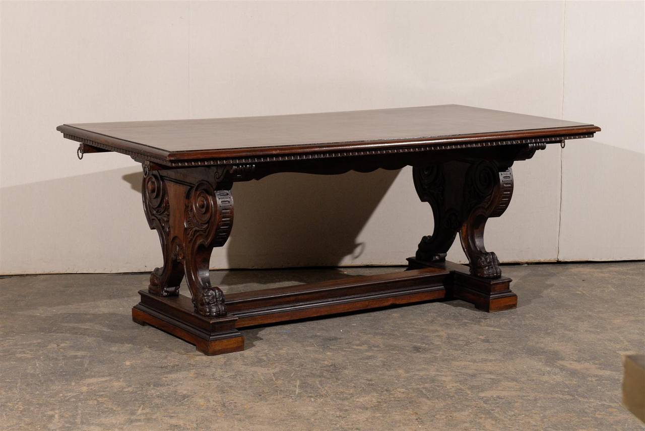 This exquisite 19th century Italian trestle table is made of richly carved sides, standing on paw feet and decorated with large volutes and floral carvings.

From the beautiful top, molding on the apron and cross stretcher, this Italian 19th