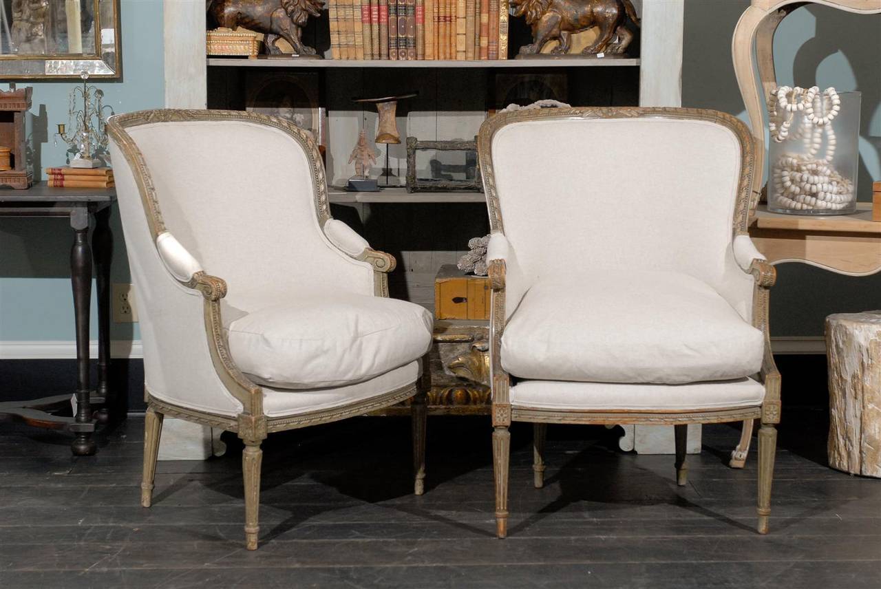 This pair of French barrel back Bergères chairs were made in the early part of the 19th century (circa 1820s).

With their fluted legs, rosettes on the knees and general detailing, they are typical of the French Louis XVI style, refined and