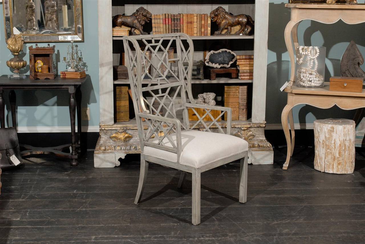 This Chinese Chippendale style wooden high back chair is painted in the light grey or blue colors. It possesses the typical simple rectilinear outlines of Chinese Chippendale chairs, with the interlocking diagonal patterns. It would also qualify as