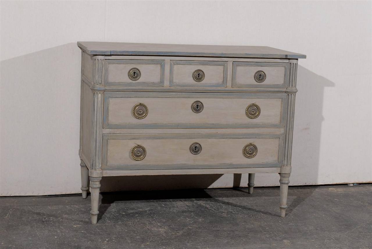 This French 19th century painted wood five-drawer chest features two larger drawers, below three smaller ones. Supported by four turned legs, it is decorated with fluted side posts, flat on the back and rounded in the front, which add a touch of