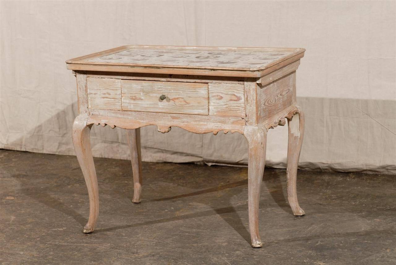 An 18th century Swedish wooden single-drawer tray top side table with 18th century Dutch tiles depicting windmills, swans and houses, cabriole legs and carved apron.
