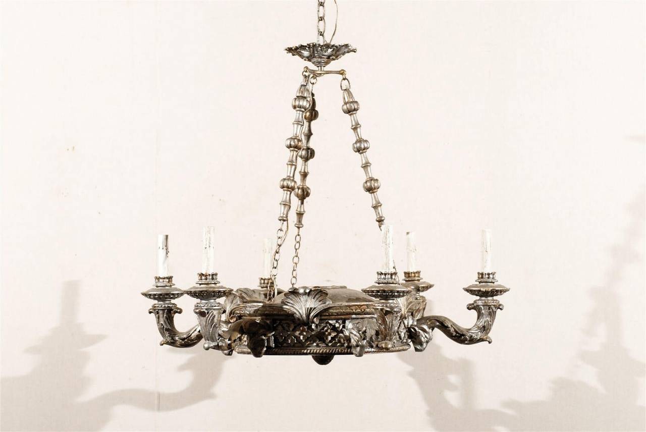 A one of a kind silver gilded six-light chandelier with carved wood ram's heads, floral and shell motifs and greatly detailed underside. 

Rewired for the US. We recommend 25 watts light bulbs.