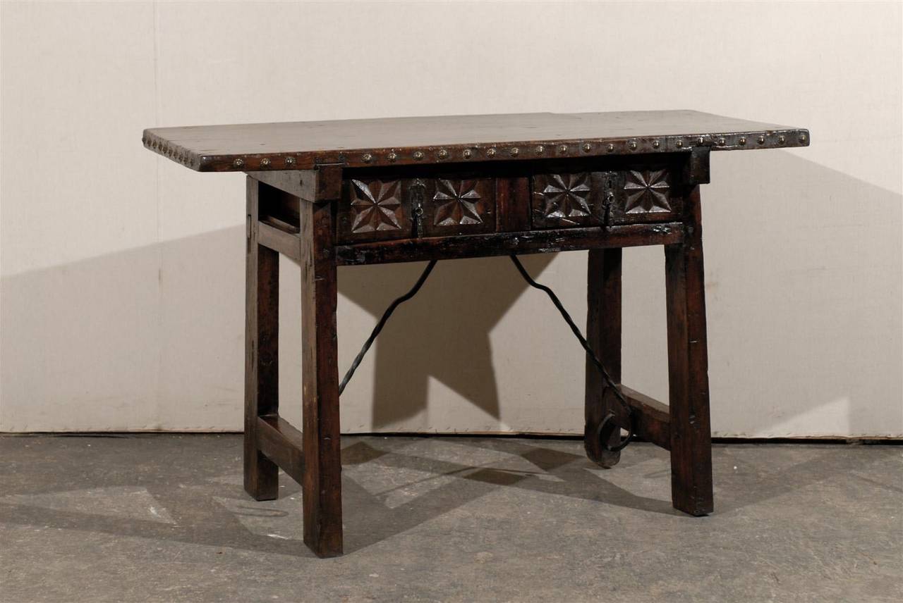A Spanish 18th century two-drawer console or side table with geometric carvings, iron stretcher and side stretchers.