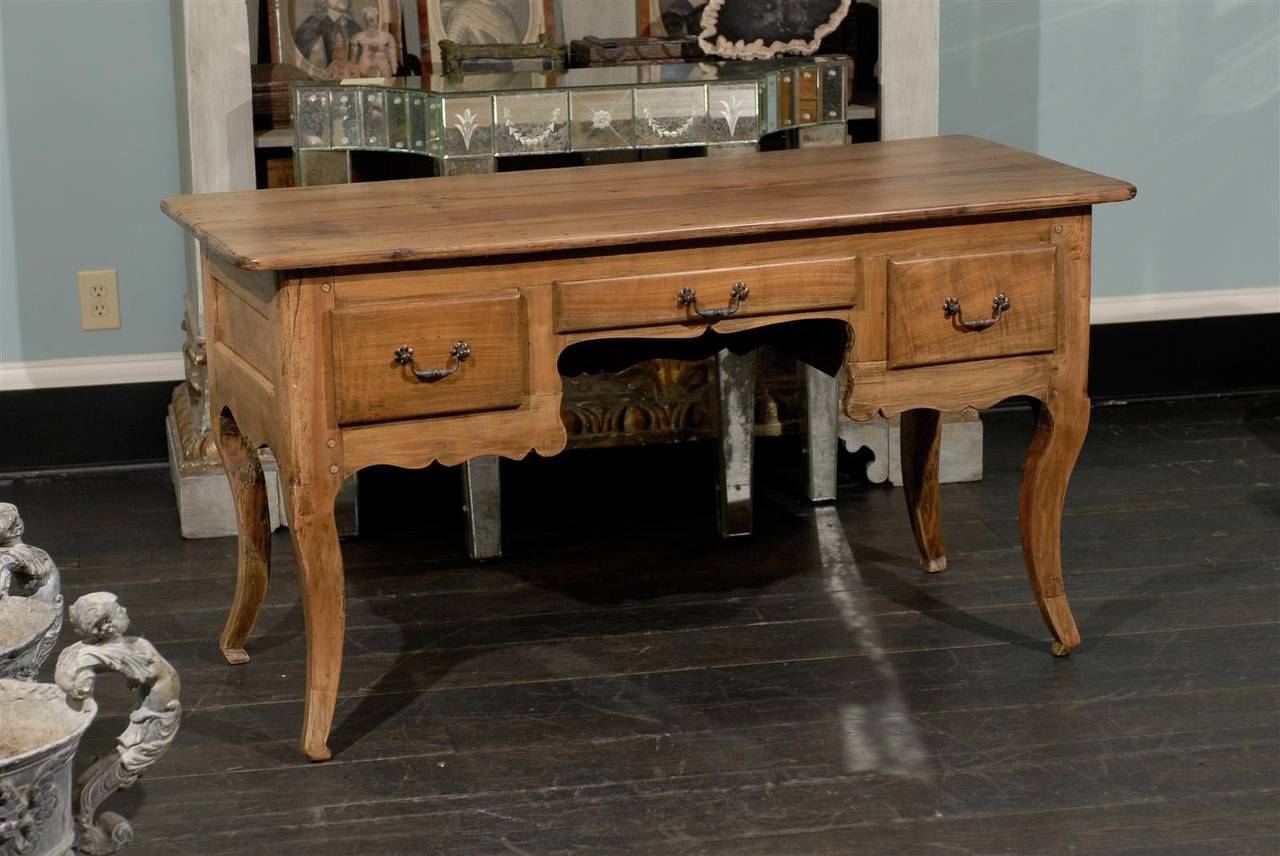 A French early 20th century wooden desk or table of small size made of fruitwood (very likely maple wood) with three drawers, slightly cabriole legs and nicely carved skirt, circa 1920. Wonderful patina and aging.