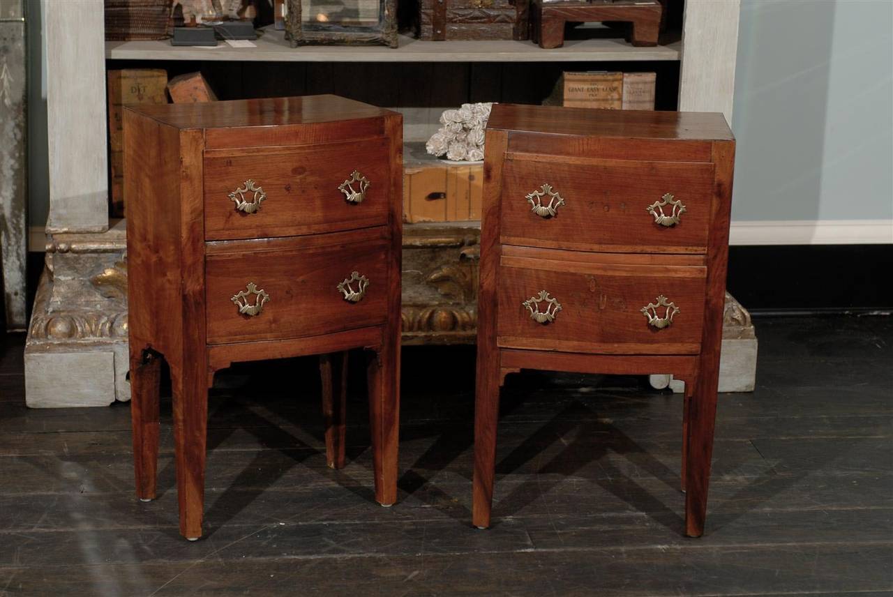 A pair of Italian early 19th century two-drawer wooden nightstand tables or chests made of fruitwoods, likely walnut and mahogany on the drawers banding.