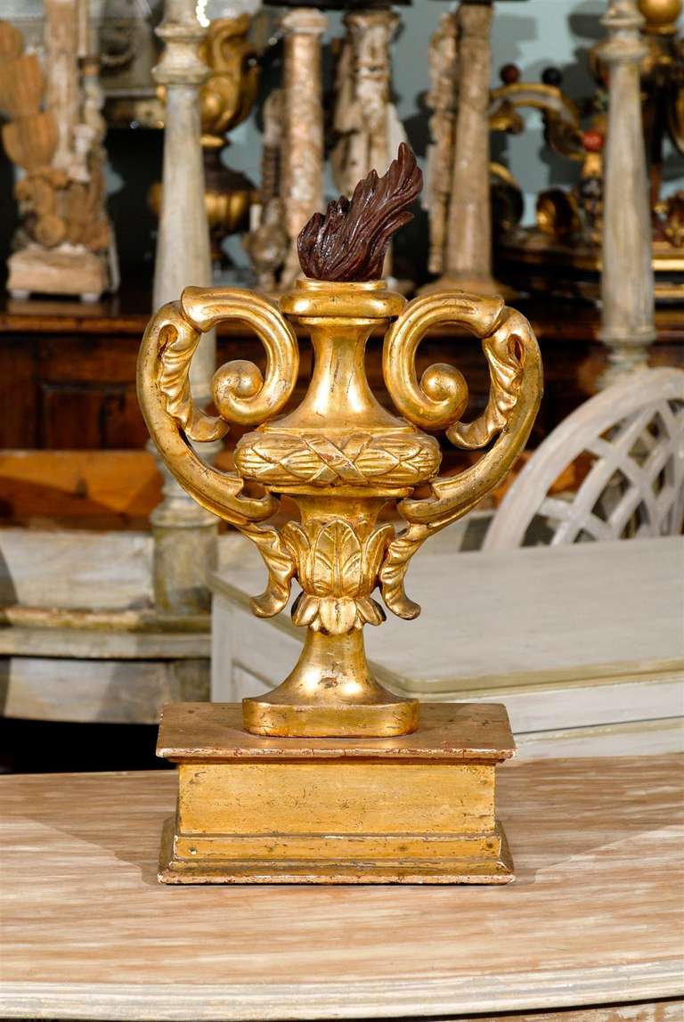 An Italian gilded and painted in the back wooden fragment on its base, depicting a Pot a` feu (Fire urn), 20th century.
The gorgeous details of the volute urn find their high point with the painted flame at the top.