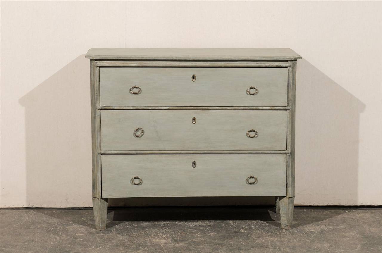 A Swedish period Gustavian early 19th century three-drawer painted wood chest with chamfered sides and tapered, angled feet.