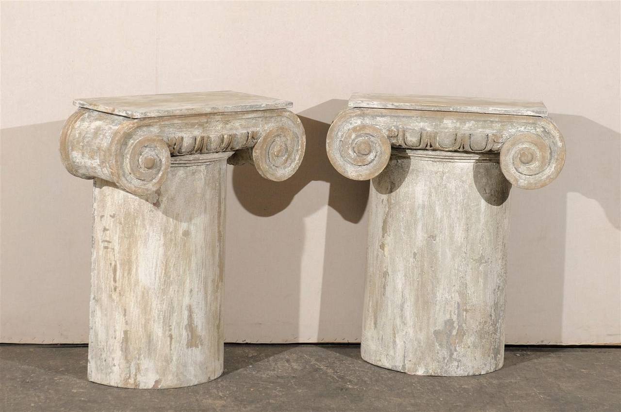 A pair of painted and carved wood American ionic capital console tables with flat backs and egg and dart motif at the top. Please look at all the additional pictures to see the back, which is hollow, 20th century.