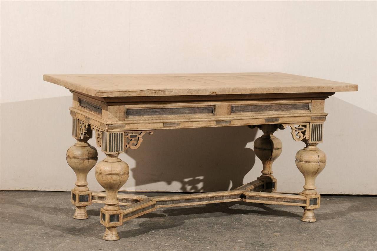 A Swedish early 19th century Baroque style table or desk of bleached wood and darker painted accents, wonderfully carved support and cross stretcher. A light coat of polyurethane has been applied for protection.