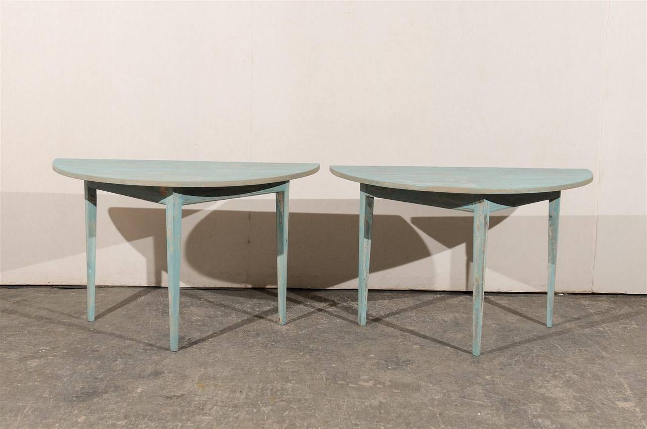 A pair of mid-19th century Swedish painted wood demilune tables with triangular base and tapered legs.