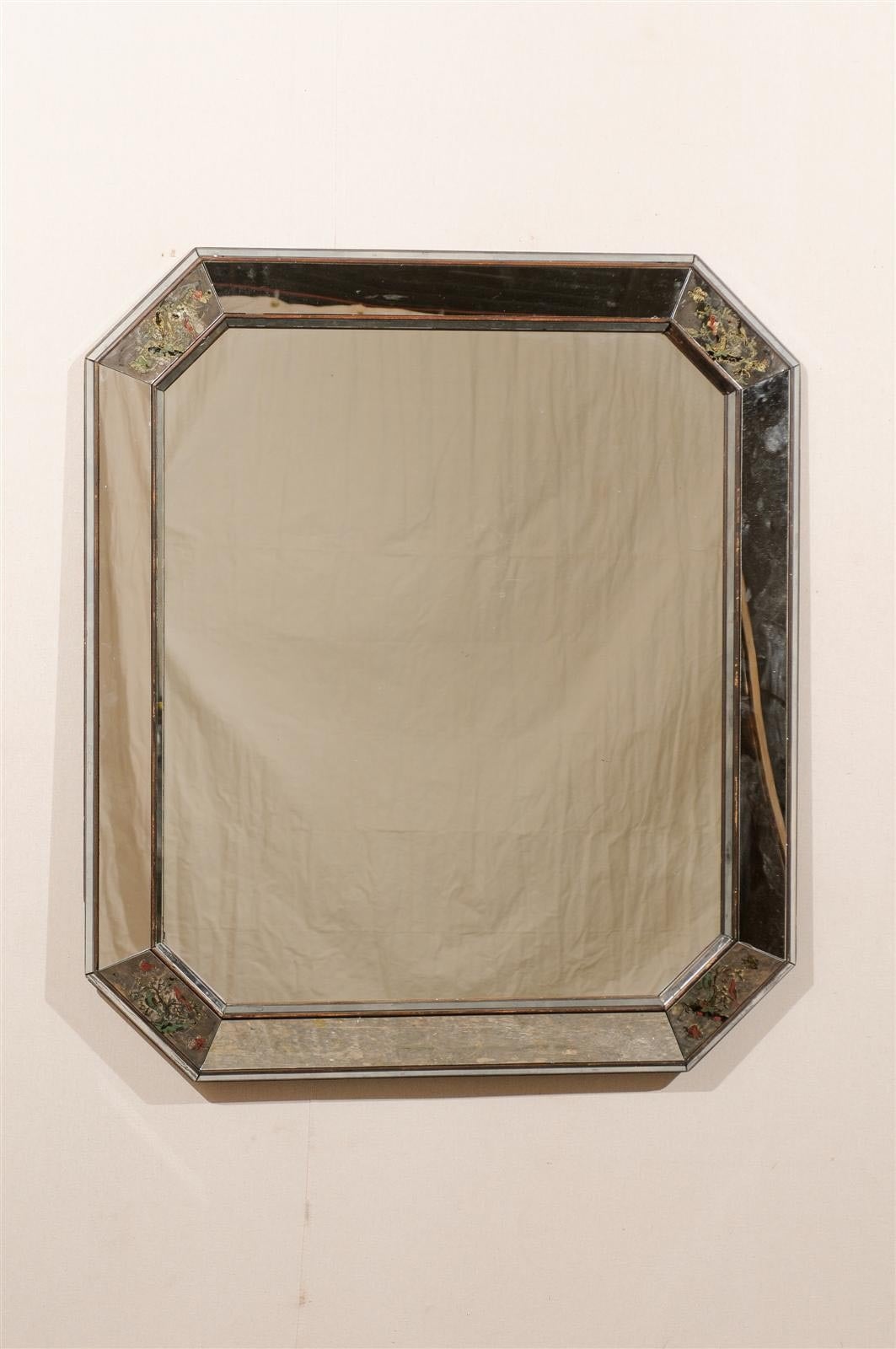 An octagonal early 20th century American mirror with lovely bird scenes painted in the corners, slightly beveled panels and wooden trim.