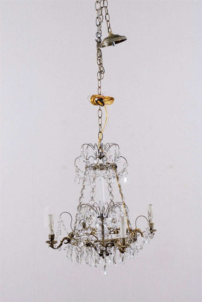 A mid-20th century Swedish four-light crystal chandelier with brass ring and bobeches and glass central column.

This crystal chandlier has been rewired for the US market and comes with a complimentary 3 foot chain and canopy painted to match.