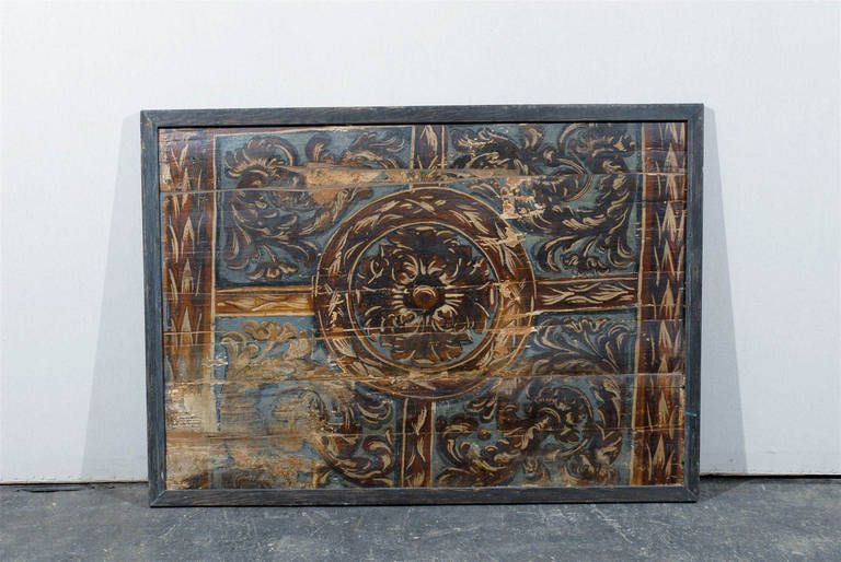 An 18th century Italian wood panel with its original paint. This Italian panel features a central painted flower and is surrounded by a décor of rinceaux (foliage).