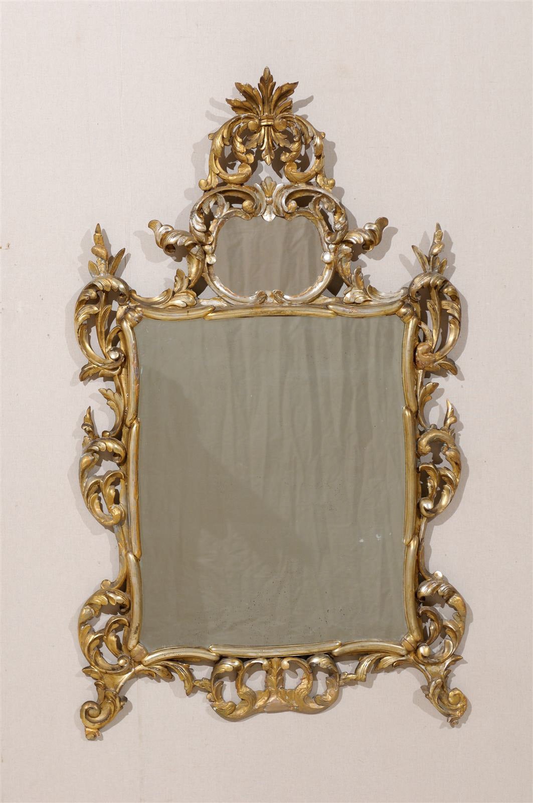 An Italian early 20th century gold and silver gilt mirror with Richly Carved wood with old mirror.