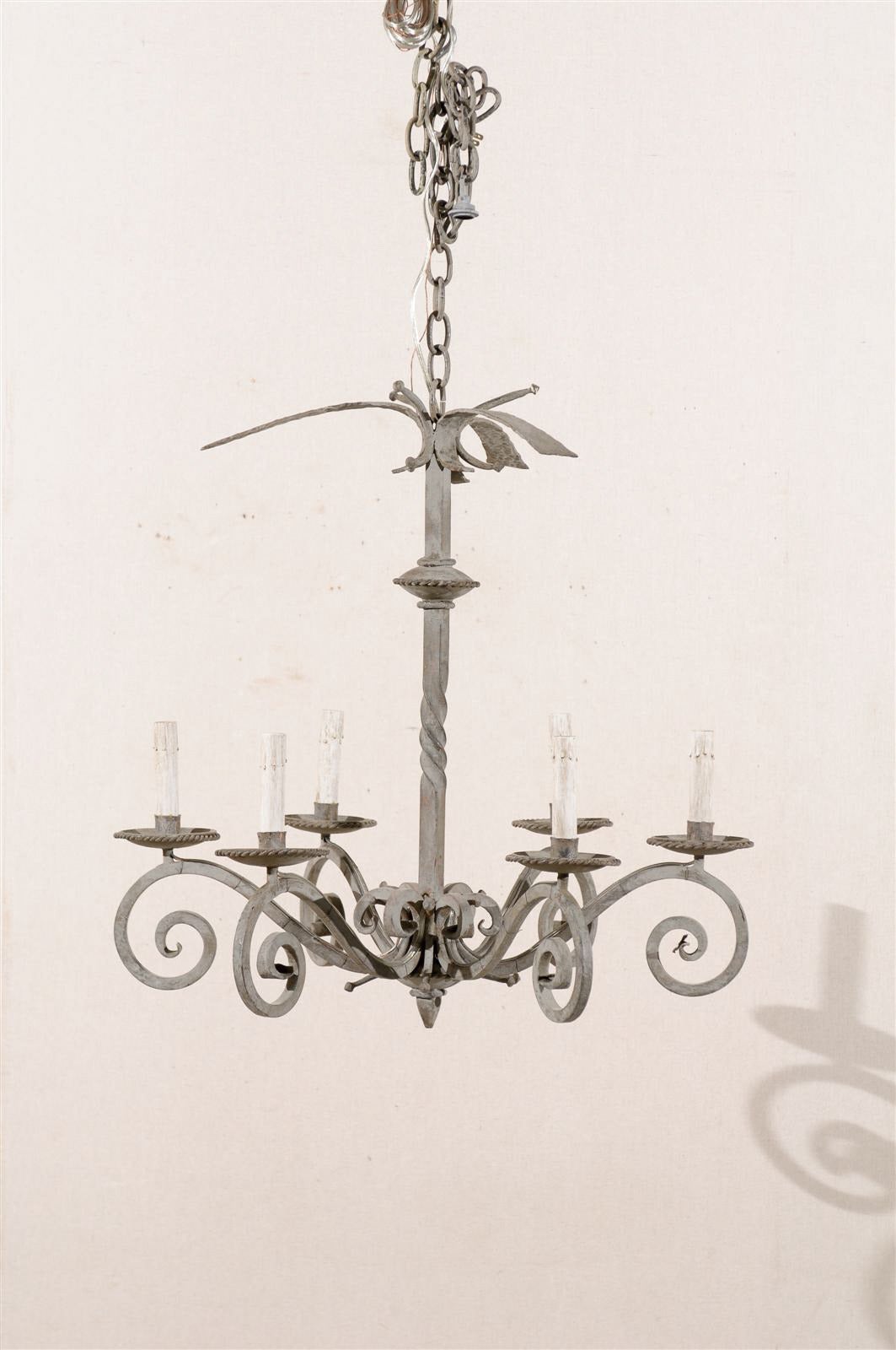A French vintage six-light painted iron chandelier with S-scrolled arms and a twisted central column. This French metal chandelier from the mid-20th century has been rewired for the US and comes with a complimentary 3-foot chain and canopy painted
